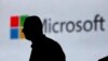 FILE - A man is silhouetted as he walks in front of a Microsoft logo at an event in New Delhi, India, Nov. 7, 2017. Microsoft says it’s uncovered new Russian hacking attempts targeting U.S. political groups ahead of midterm elections in November.